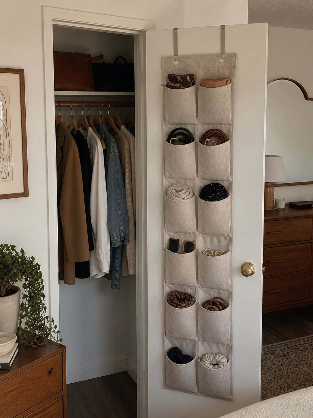 Hanging closet organizer with pockets storing accessories in a small apartment closet idea.