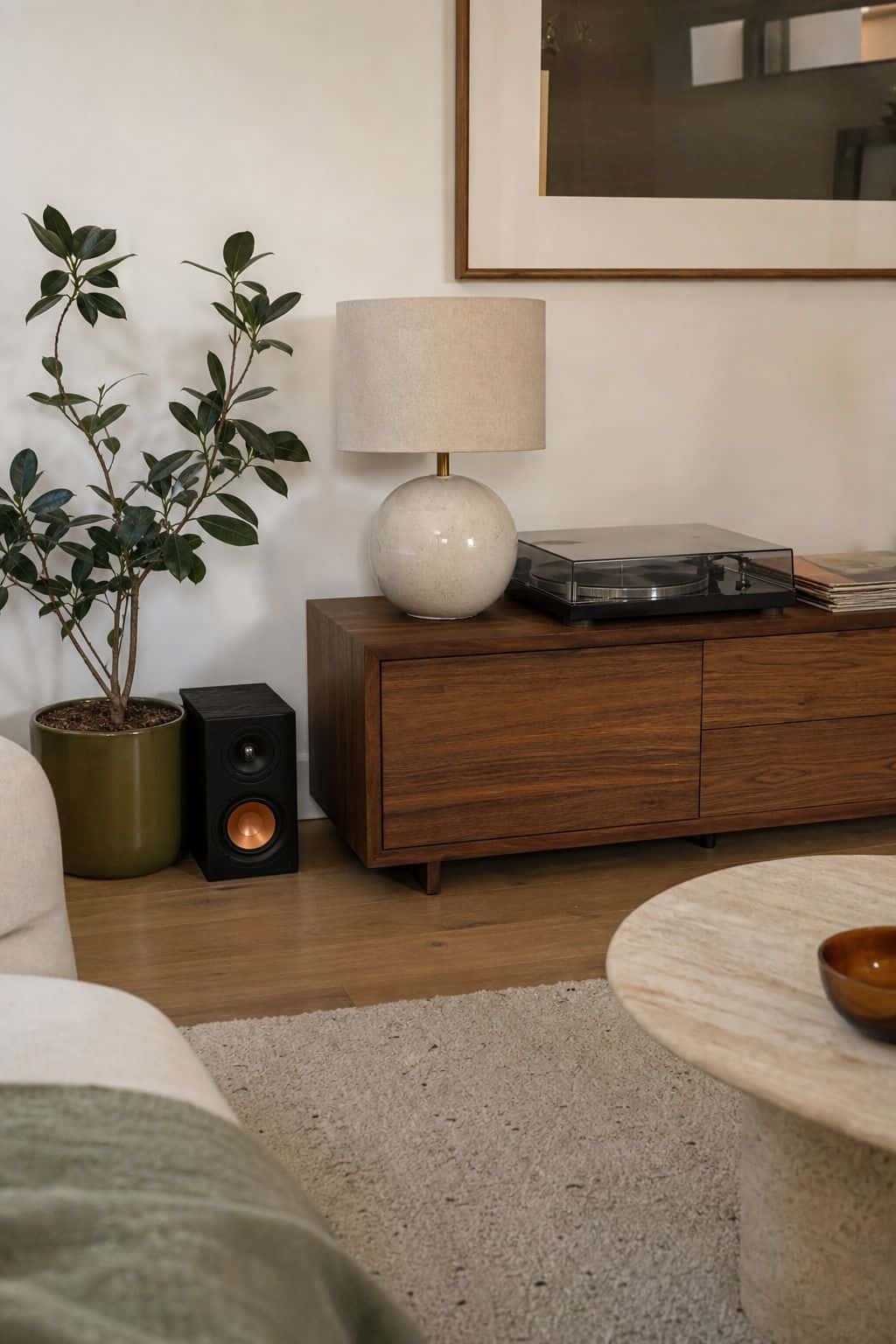 Small speaker and record player on a walnut console for summer party music