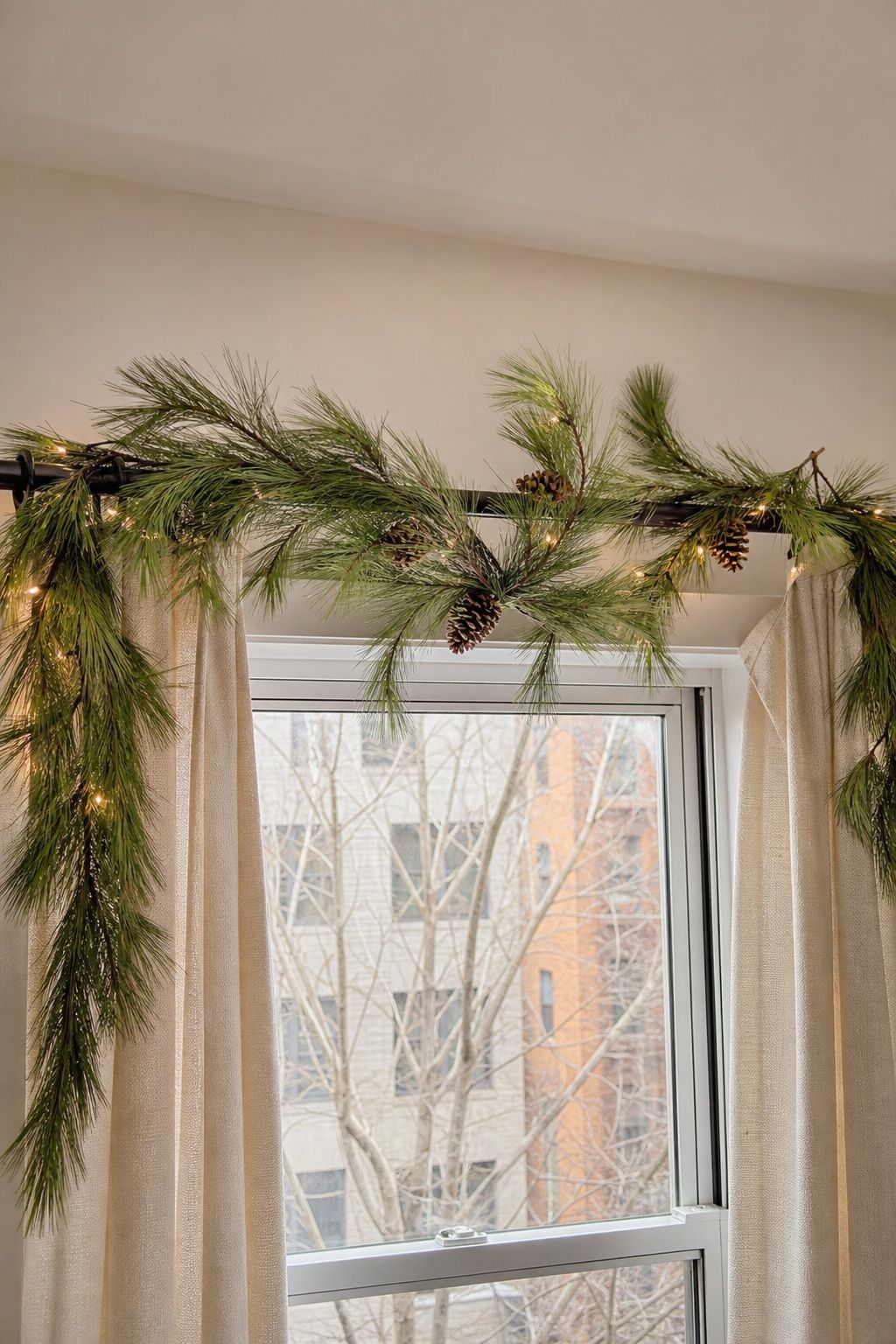 Swag Pine Branches Over Curtain Rods small apartment idea for Top 20 Small Apartment Christmas Decor Ideas for a Cozy Holiday in Tight Spaces.