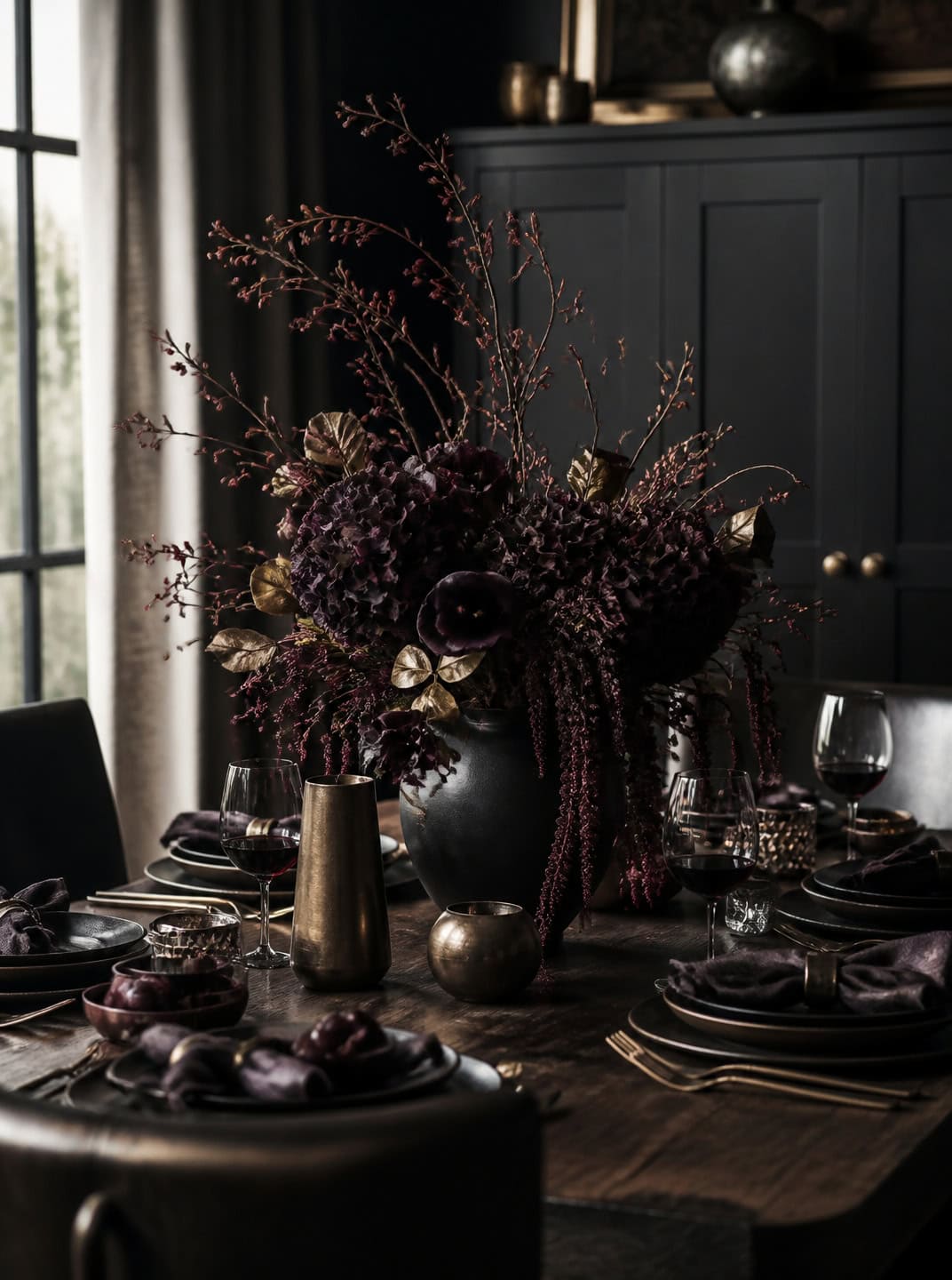 Dark, moody Halloween centerpiece with deep purple flowers and brass accents.