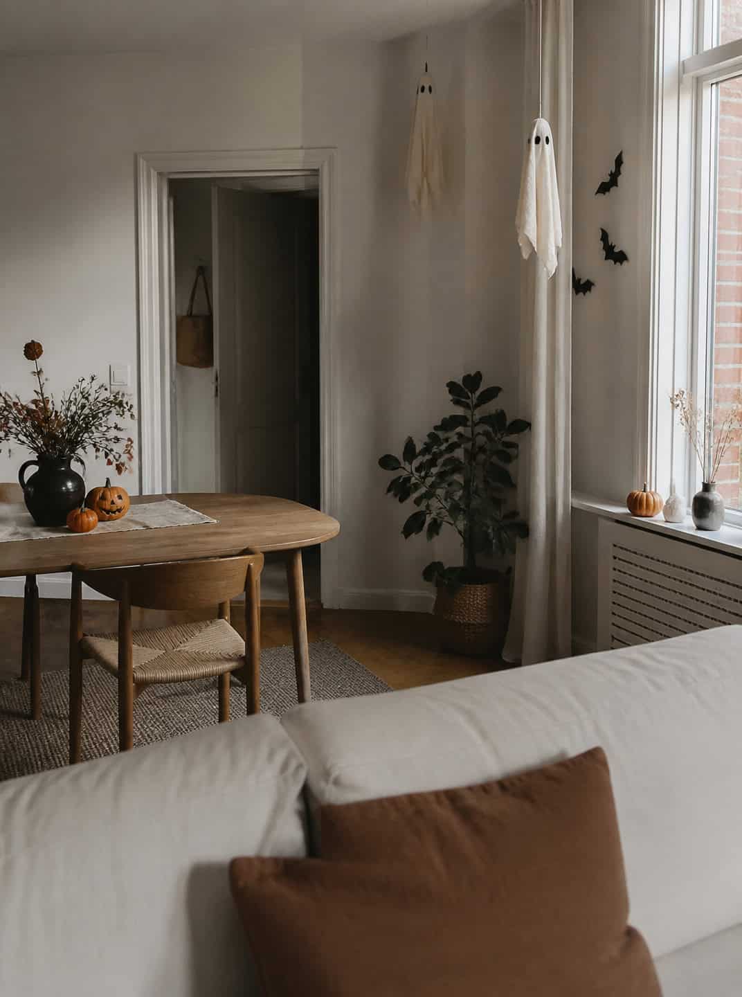 Cozy living room with indoor Halloween decoration ideas: ghost and bat decor.