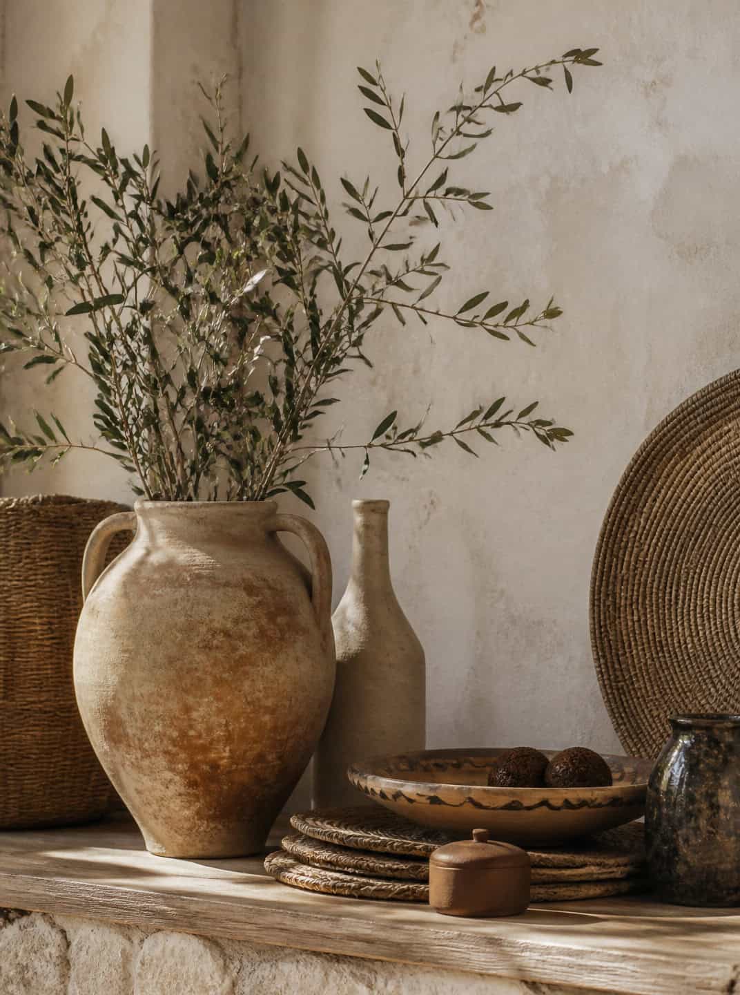 Spanish Mediterranean kitchen decor: rustic pottery, woven baskets, and olive branches.