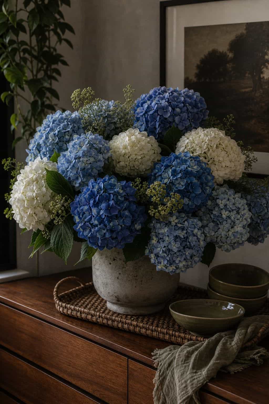 Blue and white hydrangeas in a full wedding arrangement on a walnut sideboard