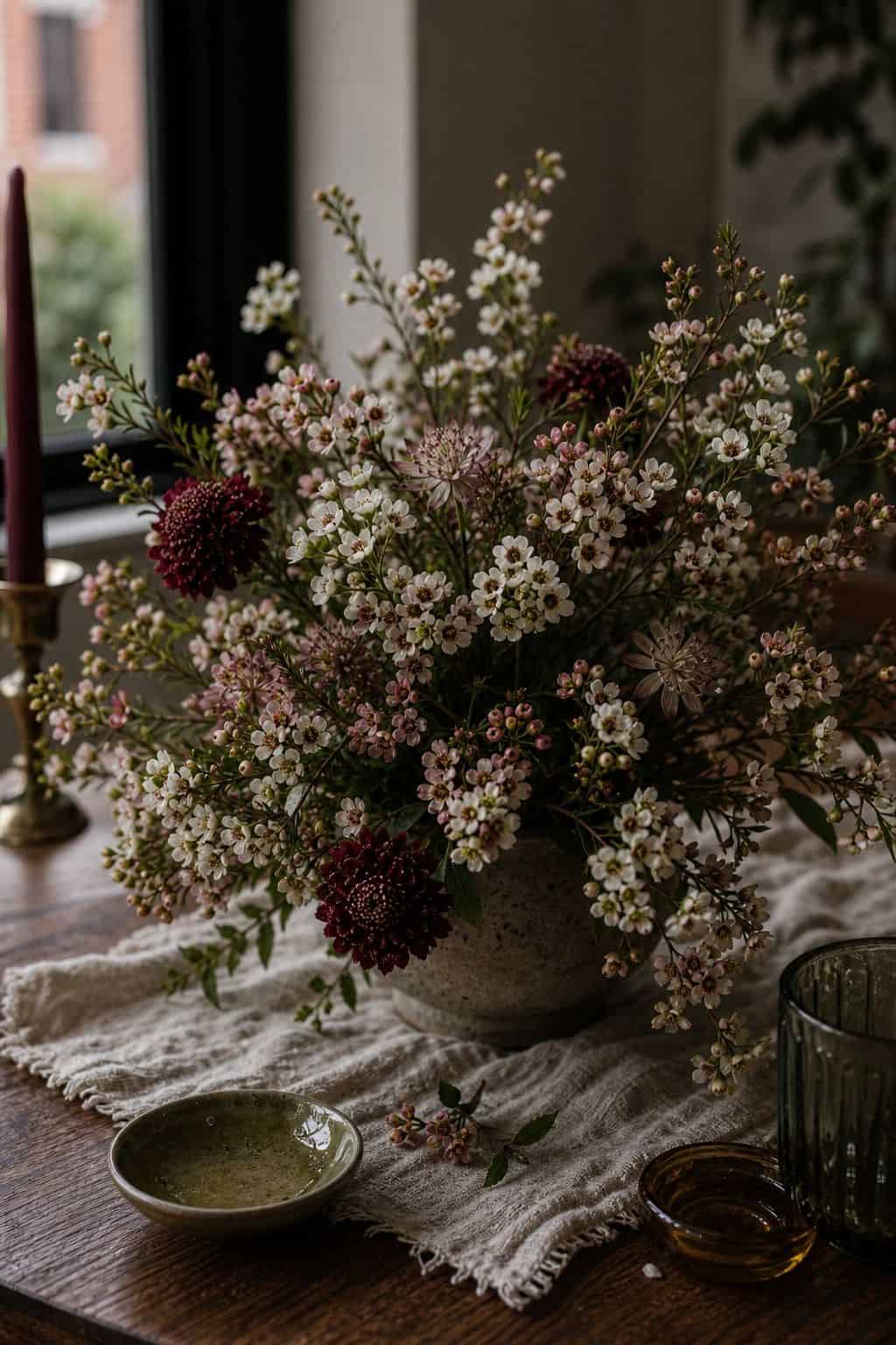 Tiny wax flower blossoms woven into a textured summer wedding floral arrangement