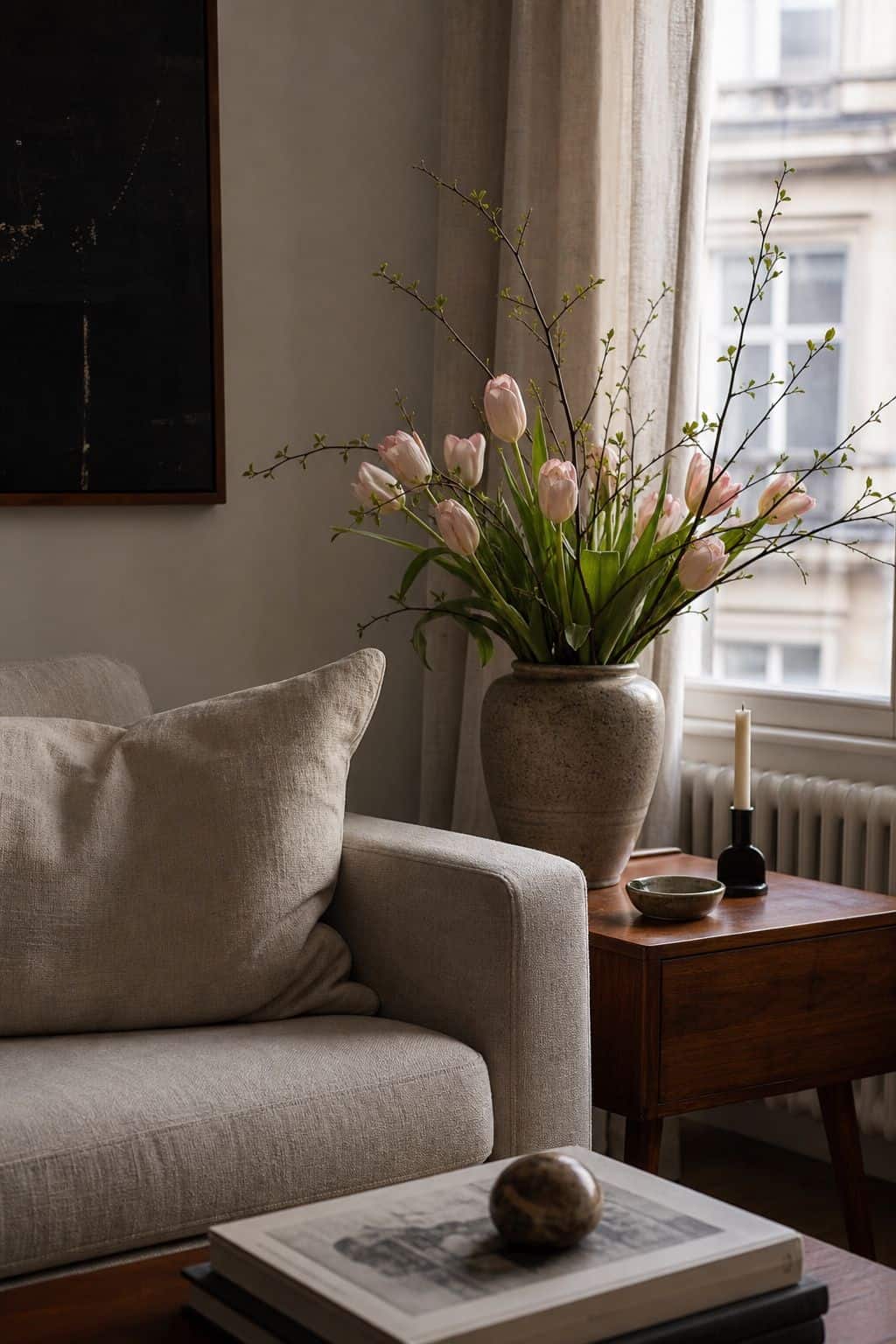 Fresh tulips and spring branches on a walnut side table in an Easter living room