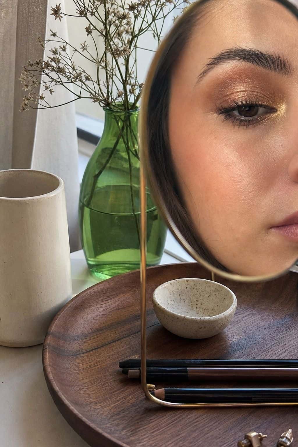 Bronze graduation eye makeup with a bright gold inner corner highlight