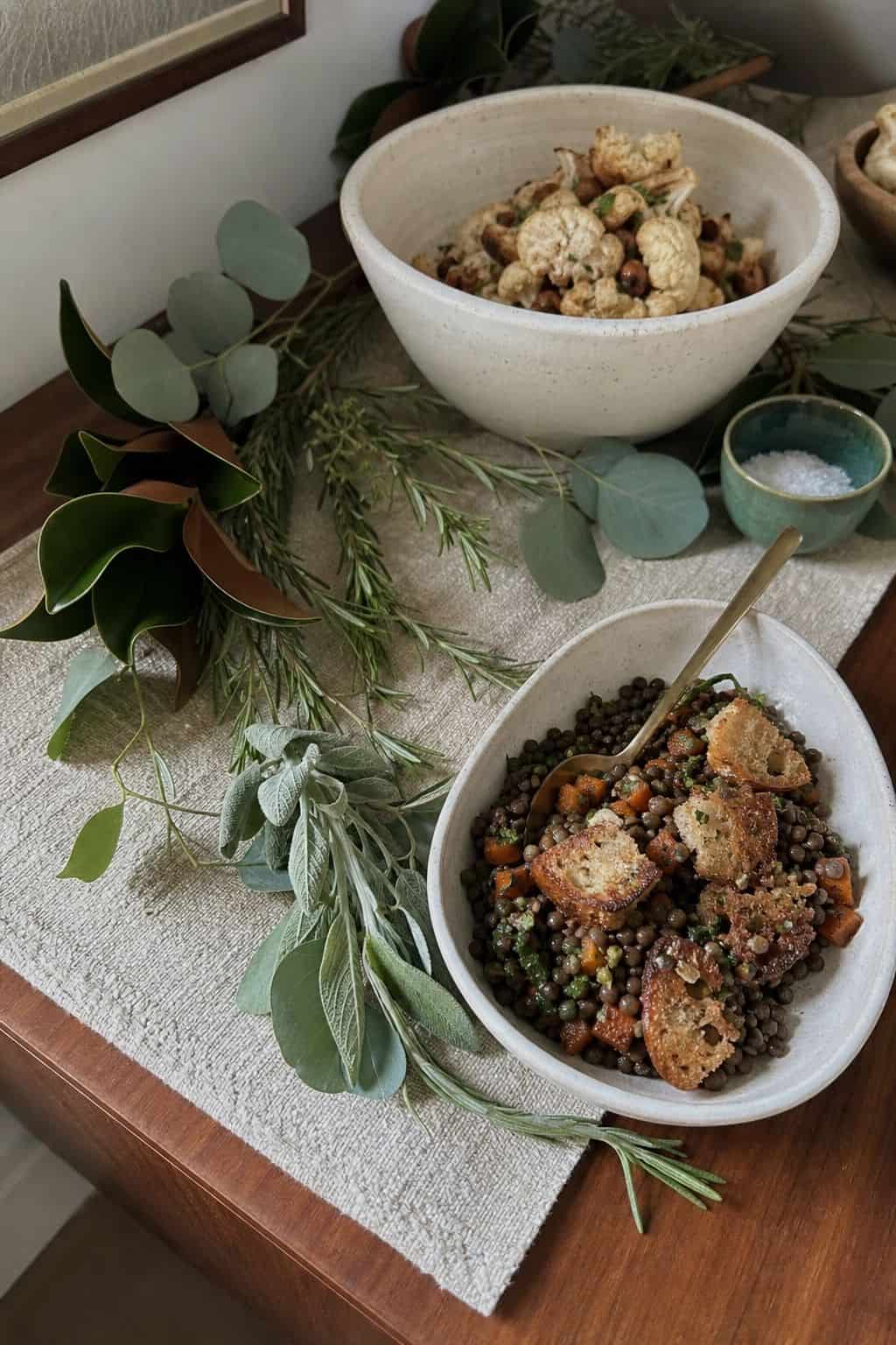 Loose rosemary, eucalyptus, and sage tucked around Thanksgiving buffet serving dishes