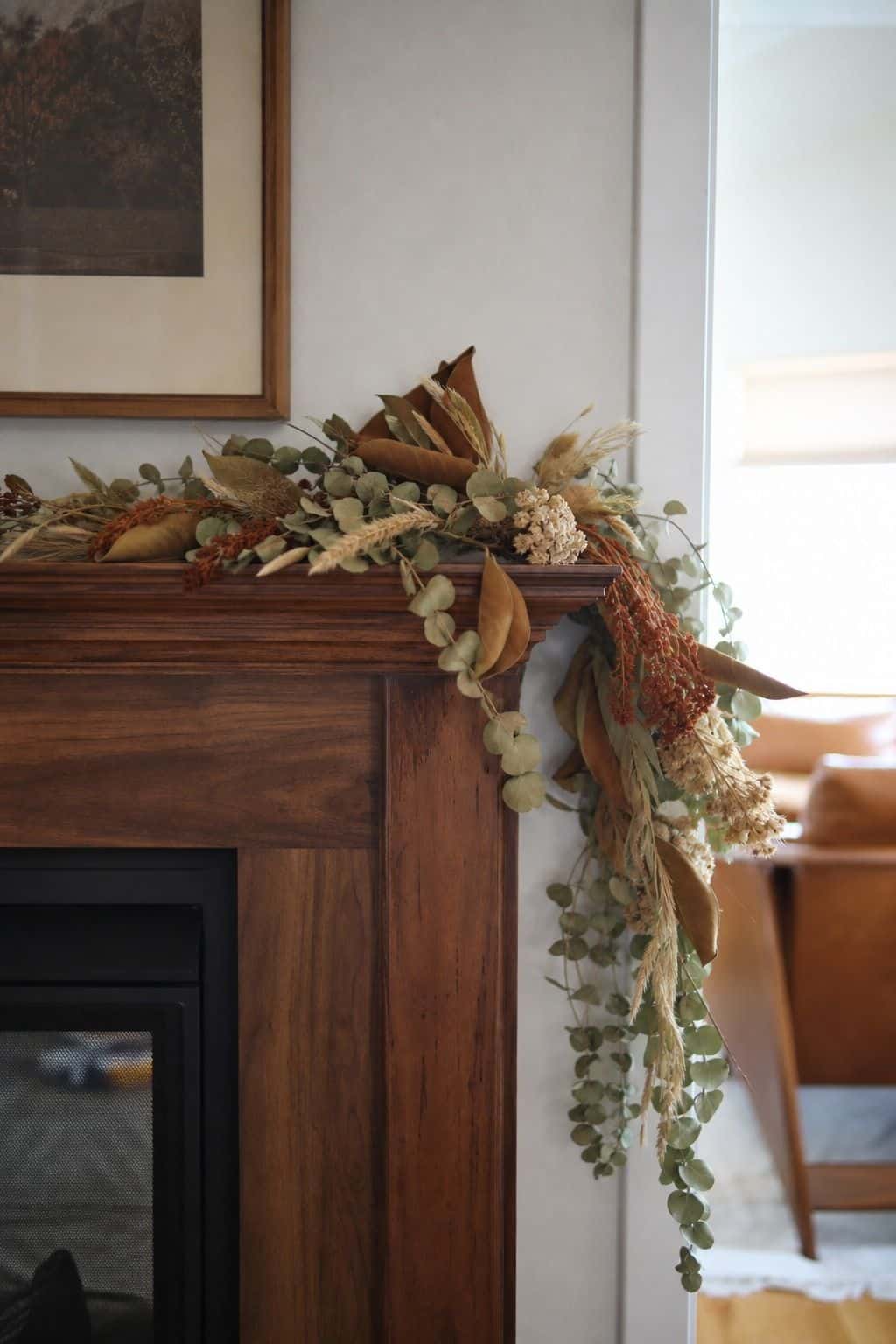 Foraged garland draped across a walnut mantel for cozy fall fireplace decor