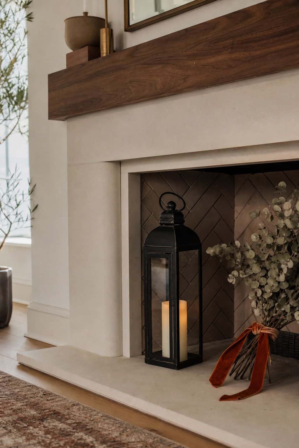 Tall black lantern with candle inside a Thanksgiving fireplace hearth