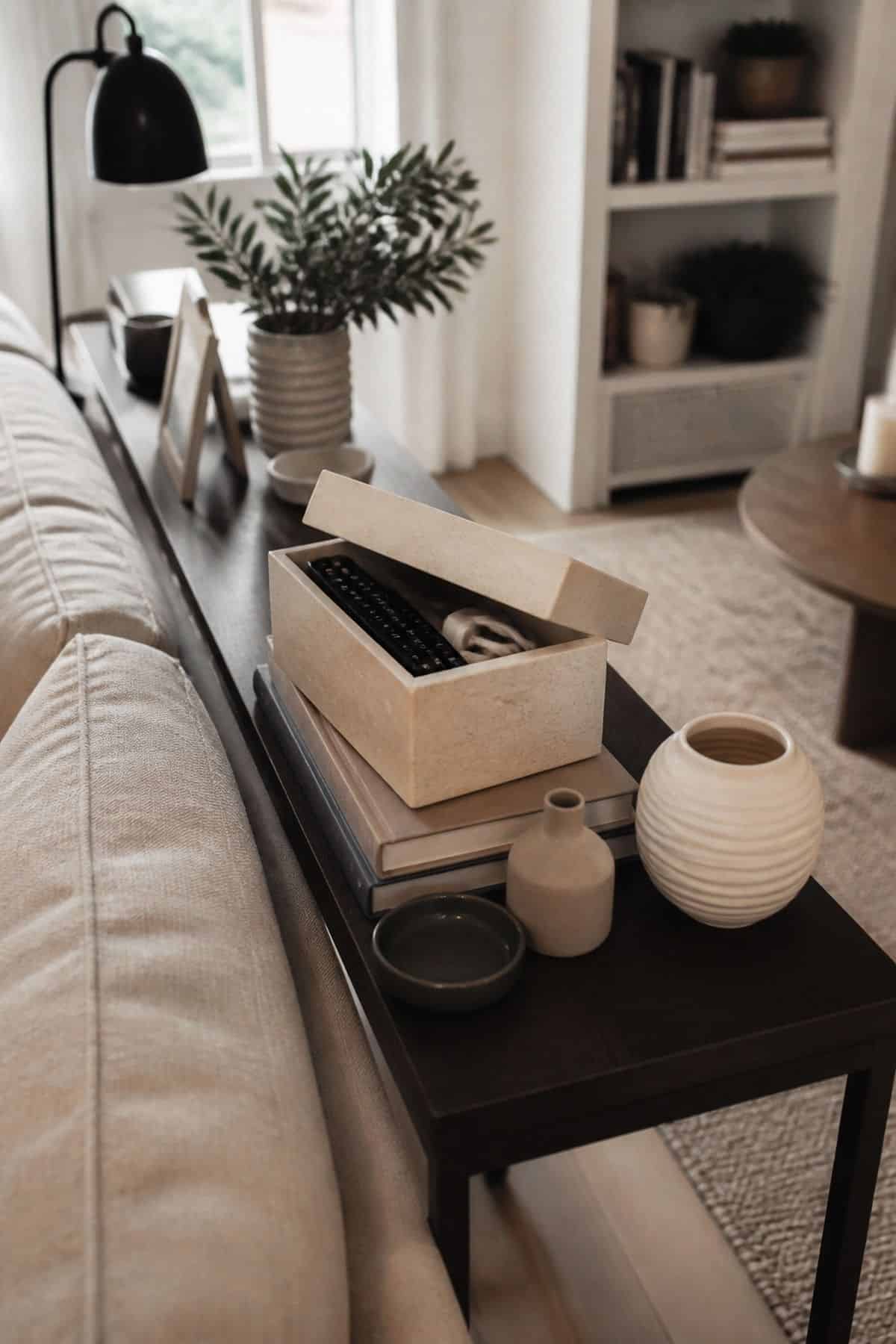 Console table behind sofa decor idea with include a decorative box for hidden storage in a small apartment living room